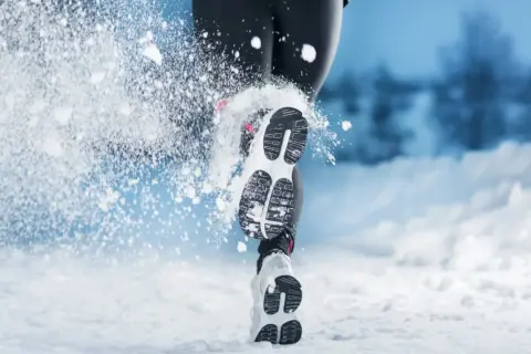 Courir dans la neige à 10 degrés : une personne en tenue de sport, chaussures de course, foulant la neige.