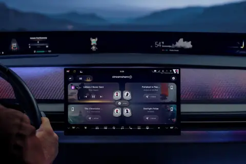 Interno auto con display touch che mostra app musicali. Icona cuffie in alto, suggerisce come collegare bluetooth per ascoltare musica.