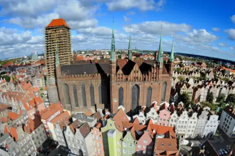 Widok z lotu ptaka na Gdańsk, z dominującym Kościołem Mariackim i kolorowymi kamieniczkami.
