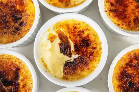 Flera crème brûlée i vita skålar, med knäckig karamelliserad yta. En riktigt god dessert!
