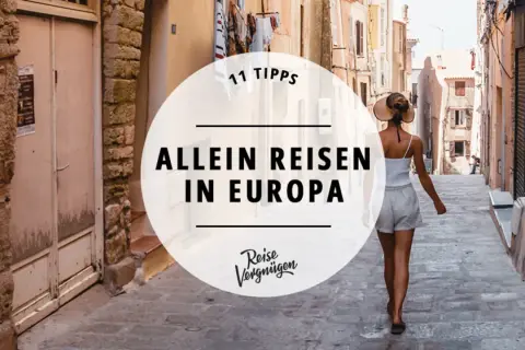 Frau mit Hut geht allein durch eine Gasse in Europa. Tipps für backpacking europa alleine.