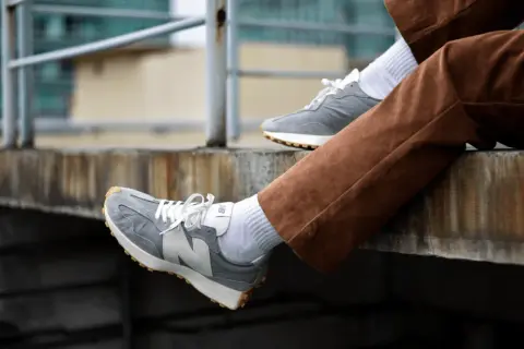 Szare New Balance na nogach w brązowych sztruksach. Zastanawiasz się, czy new balance można prać w pralce? Te wyglądają na czyste!