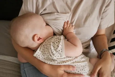 En bebis ammar. En mamma håller sitt barn nära. Dagen efter piller amning kan kännas annorlunda, men lugnet i stunden är detsamma.