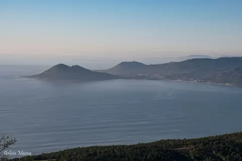 Vista panorámica de la costa gallega con el monte Enxa destacando sobre el mar azul.