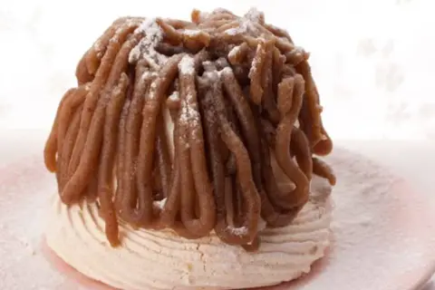 Delicioso mont blanc dulce, un postre de merengue cubierto con crema de castañas y espolvoreado con azúcar glas.