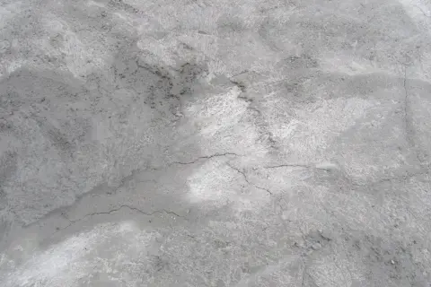 Szara, chropowata powierzchnia betonu z widocznymi pęknięciami. Czekam, aż chudziak wyschnie.