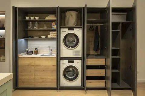 Lavaderos con encanto: lavadora, secadora, fregadero y armarios de madera. Todo organizado para un espacio funcional y estético.