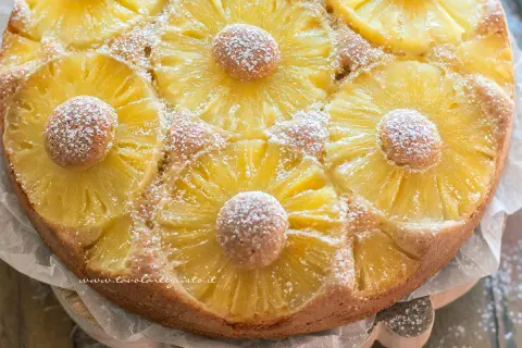 Torta ananas dorata e profumata, decorata con fette di ananas caramellato e spolverata di zucchero a velo.