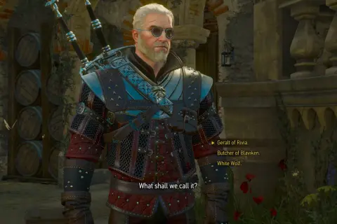 Geralt w najlepszym rynsztunku z Wiedźmina 3, gotów do walki. W tle beczki i kamienne mury.