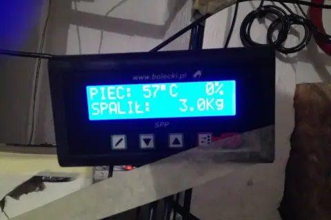 Panel sterowania pieca na ekogroszek. Wyświetla temperaturę 57°C i 3.0 kg spalonego paliwa. Automatyczne rozpalanie pieca na ekogroszek działa sprawnie.