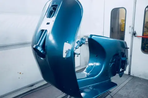 La carrozzeria di una Vespa, appena verniciata di blu metallizzato, pronta per essere rimontata. Un lavoro di verniciare Vespa senza sabbiare, per un risultato impeccabile.