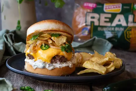 En saftig hamburgare med smält ost, jalapeños, krispiga lökringar och potatischips. Ett perfekt recept för lyxiga hamburgare hemma.