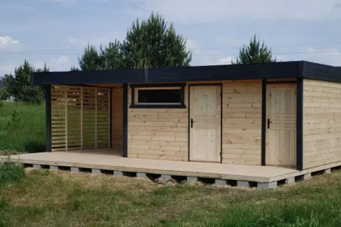 Nowy domek z tarasem na działkę, z drewnianymi drzwiami i oknem, gotowy na letnie wieczory.