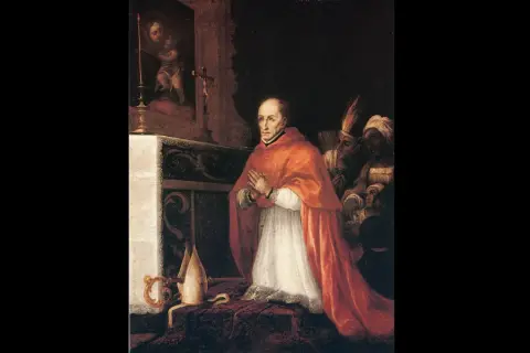 Santo Toribio de Mogrovejo, vestido de cardenal, reza ante un altar. Detrás, figuras indígenas observan.
