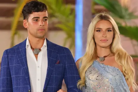 Hotel Paradise 5: uczestnicy w eleganckich strojach, mężczyzna w niebieskiej marynarce, kobieta w błękitnej sukni.