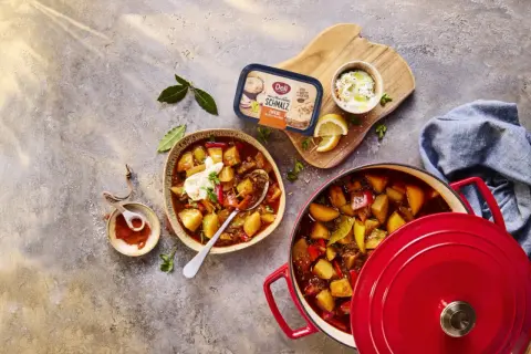 Herzhaftes Gulasch mit Kartoffeln und Paprika, perfekt zum Schmoren lassen. Daneben ein Becher Schmalz und Gewürze.
