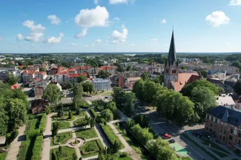 Widok z lotu ptaka na Szczecinek: zabytkowy kościół, zadbany park miejski i urokliwe kamienice. Odkryj szczecinek atrakcje!