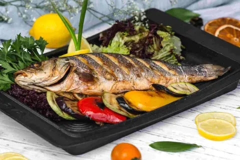 Idealne połączenie: pieczona ryba z grillowanymi warzywami i cytryną. Zastanawiasz się, czym przyprawić rybę? Ta kompozycja to dowód, że prostota jest kluczem.