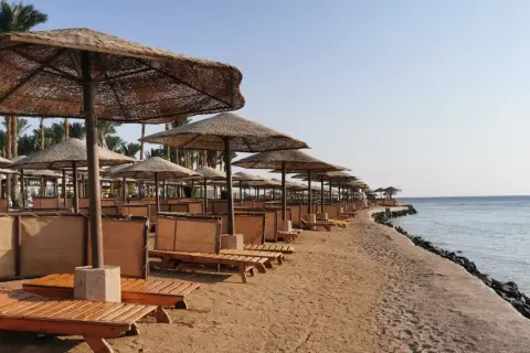 Plaża w Egipcie z rzędami leżaków i parasoli. Zastanawiasz się, ile kosztuje wiza do Egiptu, by tu wypocząć?