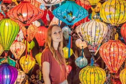 Kobieta wśród kolorowych lampionów, tworzących magiczną atmosferę wietnamskiego Nowego Roku.