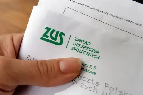 Dłoń trzyma dokument ZUS. Może to być pismo dotyczące sześciomiesięczną odprawa emerytalna.