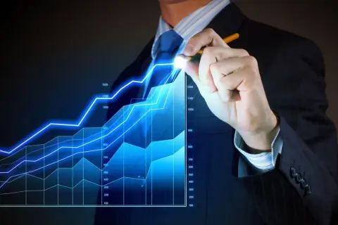 Biznesmen rysuje na ekranie wykres wzrostu finansowego.