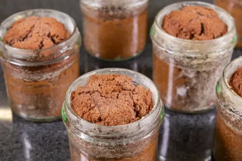Mehrere kleine Schokoladenkuchen im Glas, bereit zum Genießen.