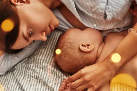 Mama czule patrzy na dziecko, które karmi piersią. Czasem pojawia się kryzys laktacyjny w 4 miesiącu, ale miłość i bliskość pomagają go pokonać.