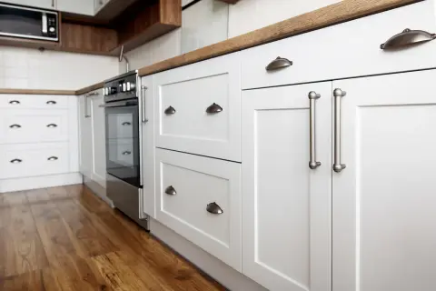 Cuisine moderne avec meubles blancs et poignées argentées. Un projet de rénovation de meuble cuisine réussi, alliant style et fonctionnalité.