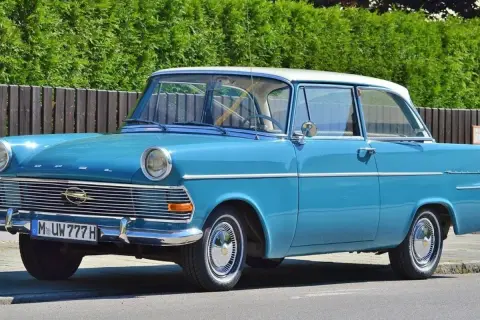 Blauer Oldtimer mit weißem Dach und dem Kennzeichen M UW 777 H. Ein Klassiker auf der Straße.