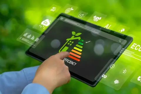 Dito un tablet mostra un grafico di efficienza energetica, con icone che simboleggiano la sostenibilità e la riqualificazione energetica globale.