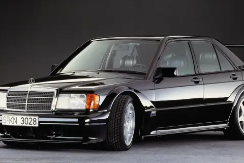 Czarny Mercedes 190E Evo II z charakterystycznym spoilerem i szerokimi nadkolami, gotowy do wyścigu.