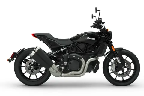 Czarny motocykl Indian FTR 1200 z charakterystycznym logo Indian na baku. Widok z boku na jego sportową sylwetkę i podwójny wydech.
