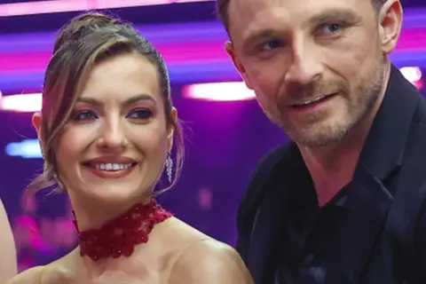 Kamil Nożyński z partnerką na scenie, uśmiechnięci i pełni energii.