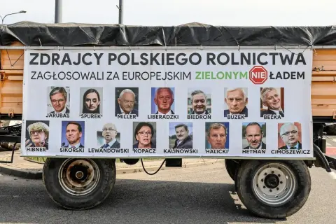 Plakat na przyczepie z portretami europosłów i napisem "Zdrajcy polskiego rolnictwa".