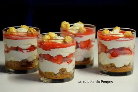 Quatre verrines fraise mascarpone spéculoos, garnies de crème et de pop-corn caramélisé. Un délice !