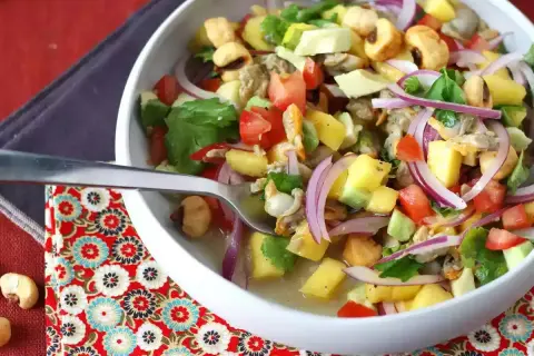 Delicioso ceviche de berberechos con mango, aguacate, tomate y cebolla morada. Una explosión de sabor fresco y vibrante.