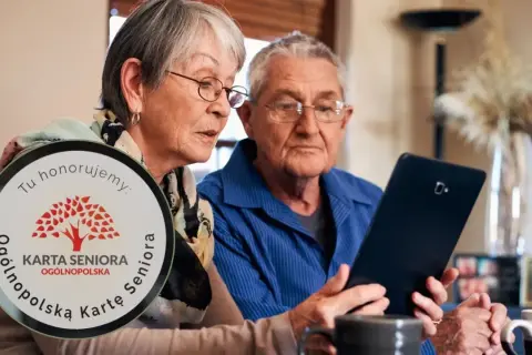 Para dowiedzieć się, jak zdobyć Kartę Seniora, starsza para wspólnie przegląda informacje na tablecie.