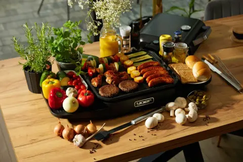 Pyszne kiełbaski, burgery i szaszłyki na grillu. Idealne składniki na to, co na grilla tanio i smacznie. Warzywa, pieczywo i dodatki dopełniają obraz.