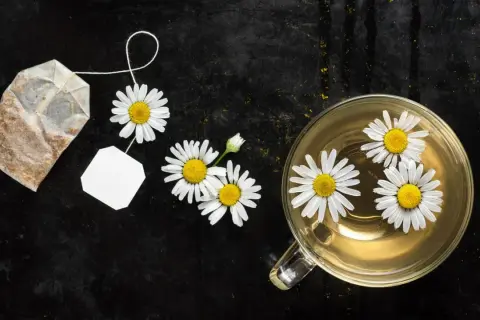 Kamillentee mit frischen Blüten und Teebeutel. Ein natürliches Hausmittel, um die Verdauung schnell anzuregen.