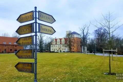 Zamek Topacz: drogowskaz wskazuje drogę do muzeum, oficyny, sali balowej, kolumnowej i kominkowej. Atrakcje czekają!