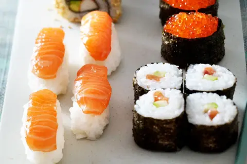 Frisches Sushi-Rezept: Nigiri mit Lachs, Maki-Rollen mit Lachs und Gurke, und Ikura-Gunkan.