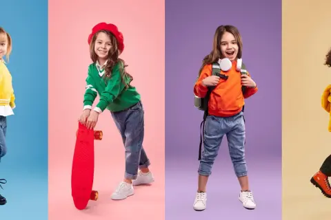 Cztery dziewczynki w modnych stylizacjach. Jedna w żółtym sweterku, druga z deskorolką, trzecia z plecakiem, czwarta w jesiennej kurtce. Rozmiar 122 pasuje na wiek 6-7 lat.