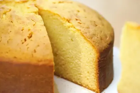 En saftig, gyllene glutenfri tårtbotten med en bit borttagen, som visar den fluffiga insidan. Perfekt för alla tillfällen.