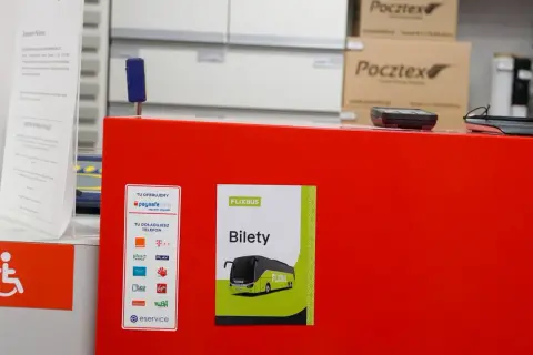 Na czerwonym blacie znajduje się naklejka z napisem "FLIXBUS Bilety", wskazująca, gdzie kupić bilet na Flixbus. Obok widać też logo paysafecard.