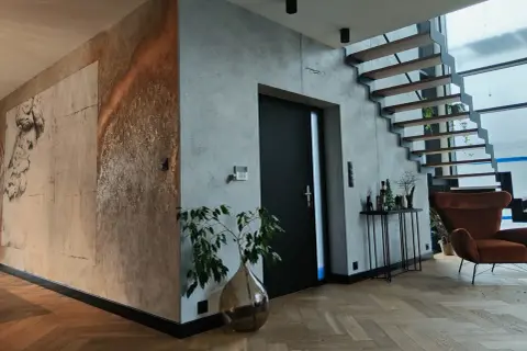 Nowoczesne wnętrze z betonem architektonicznym i grafiką na ścianie. Czy tynk dekoracyjny można malować? Tak, a efekt może być zachwycający!
