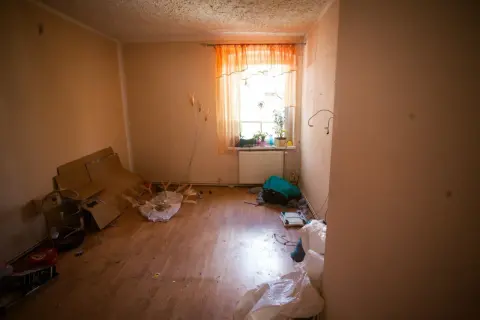 Zalane mieszkanie, stosy kartonów, klatka dla ptaków i worki. Spółdzielnia ponosi odpowiedzialność za zalanie mieszkania, co widać po zniszczeniach.