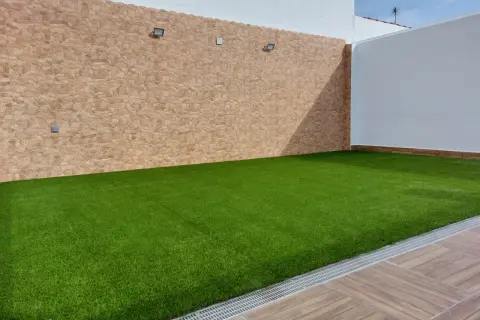 Césped artificial verde vibrante sobre una base impecable, ideal para crear tu oasis.