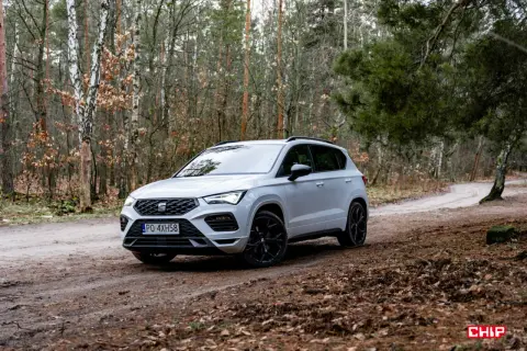 Biały Seat Ateca na leśnej drodze, gotowy na przygodę.