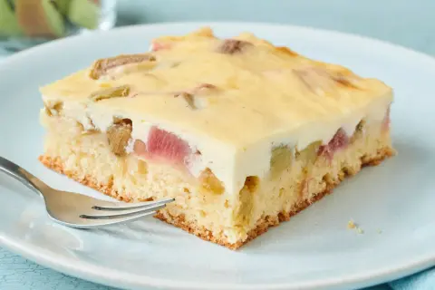 Ein Stück Rhabarberkuchen mit Pudding, saftig und lecker, wartet auf dich.